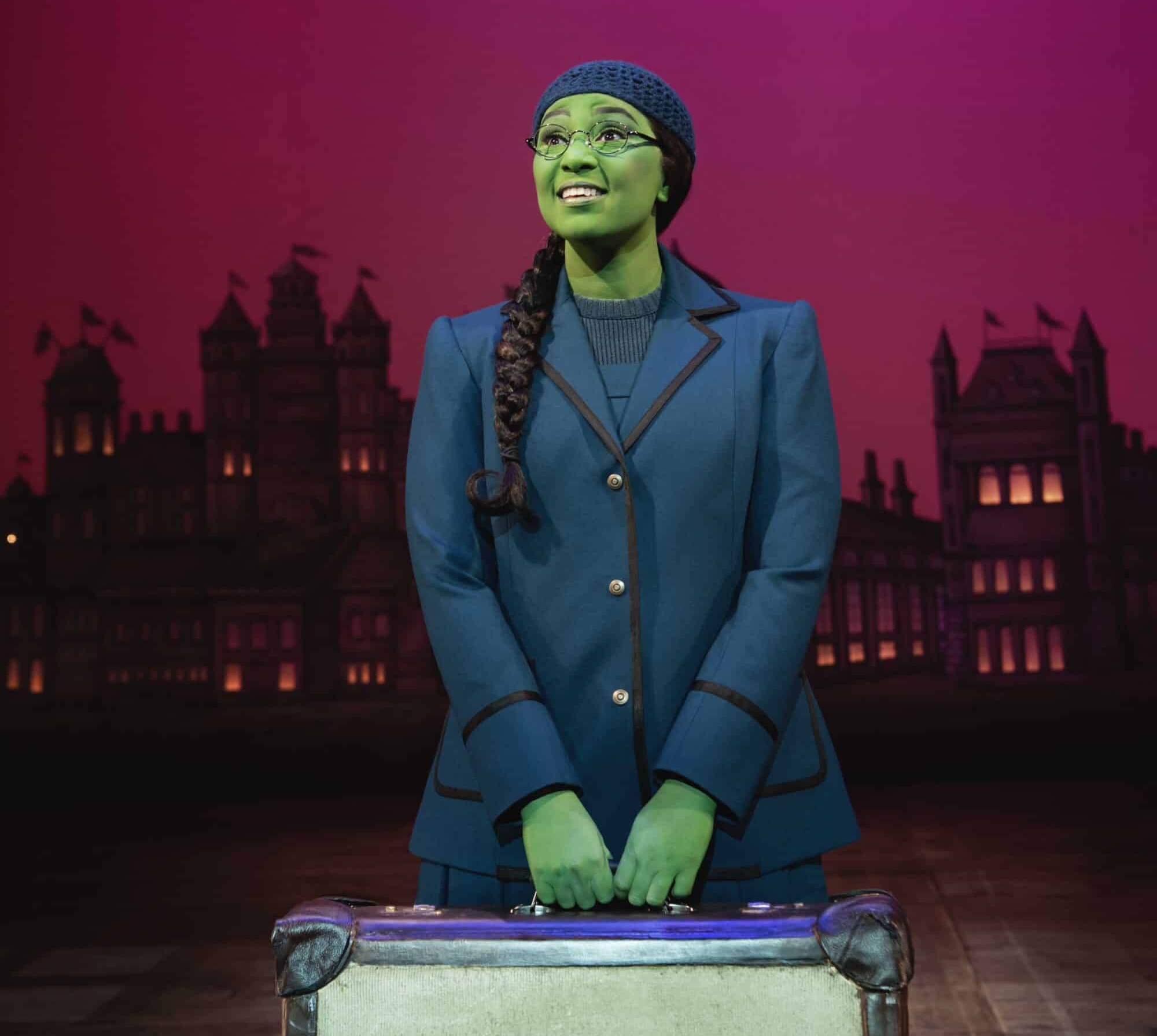 Elphaba holding a suitcase at Shiz University