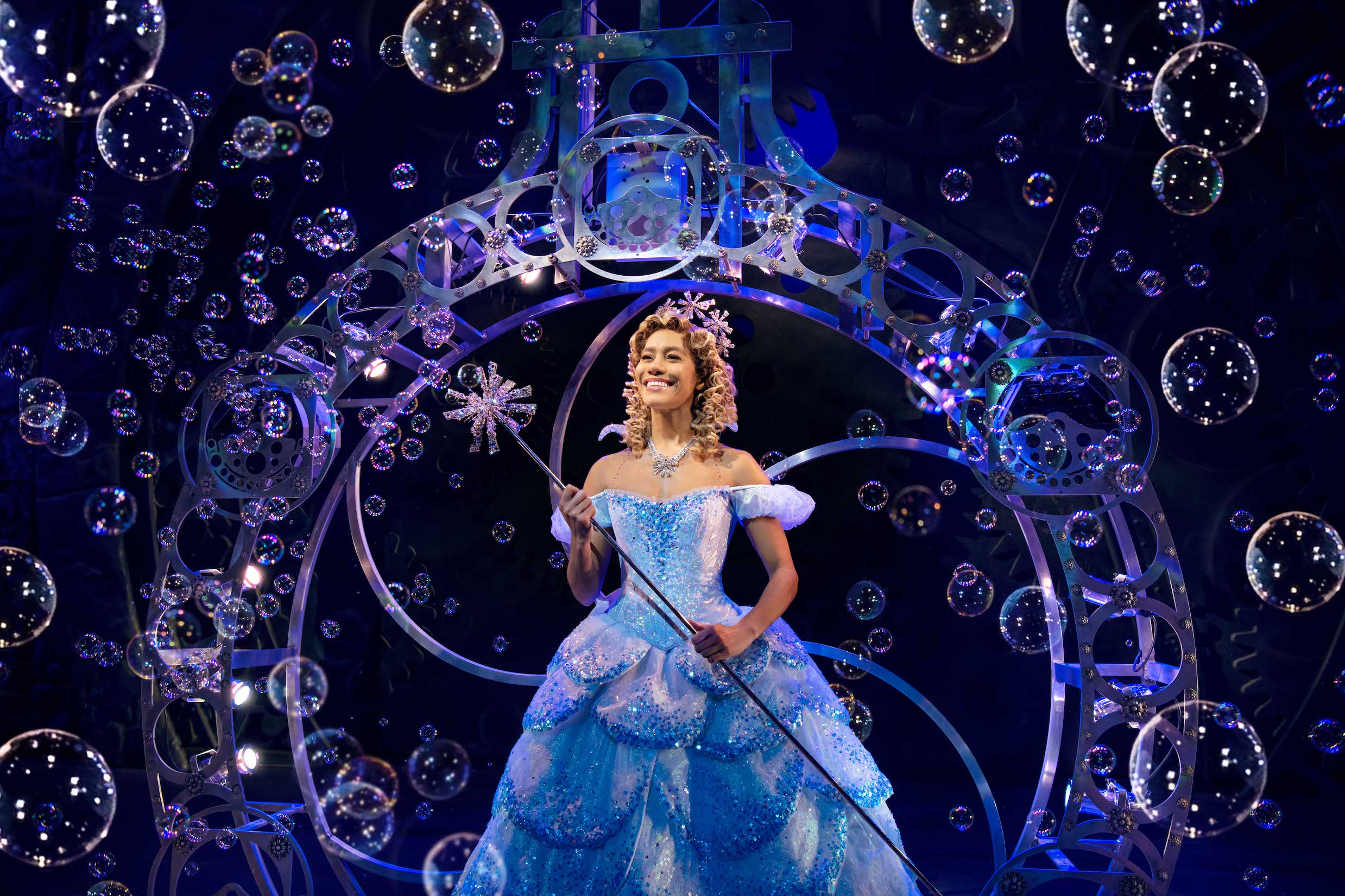 Glinda descending in her bubble with dozens of ubbles floating around her.